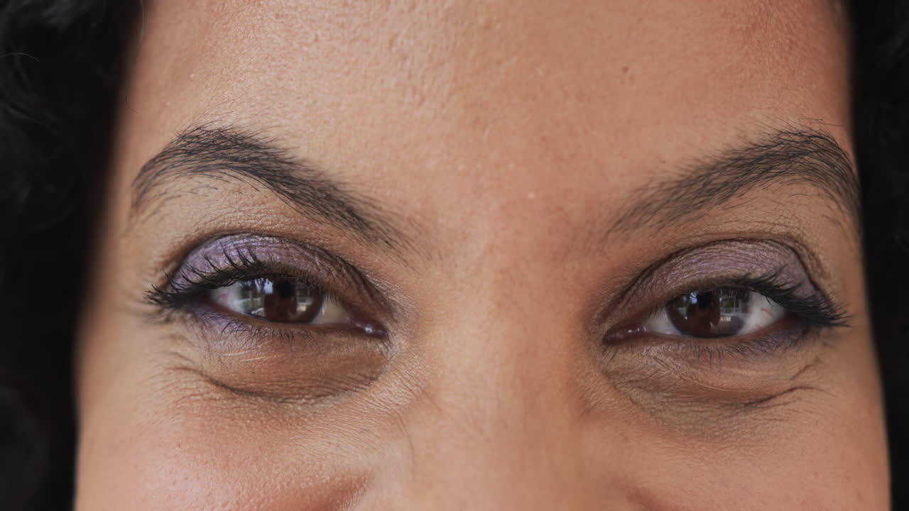 Close up portrait of happy eyes of biracial woman at home, slow motion