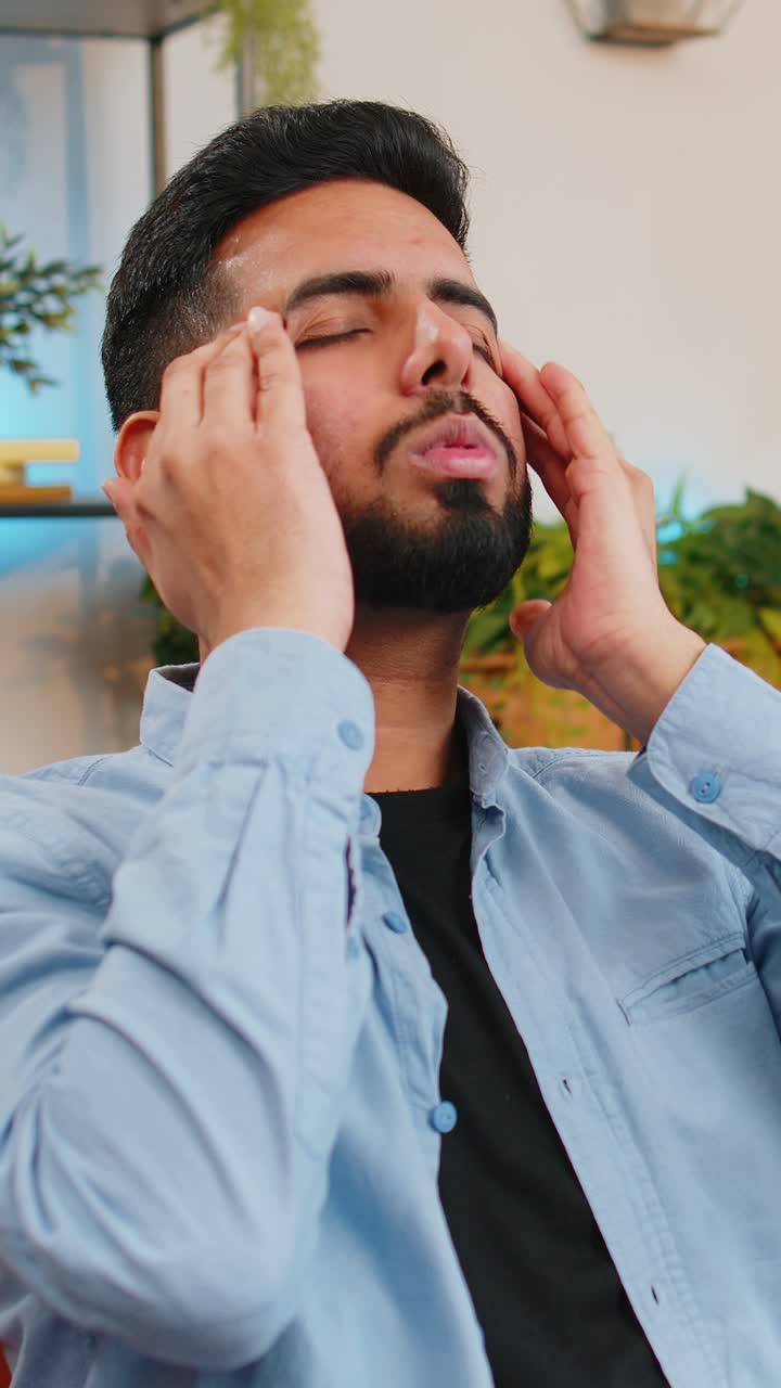 Sick indian man rubbing temples to cure headache problem suffering from tension migraine stress