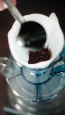 ground coffee beans, pouring into filter for brewing
