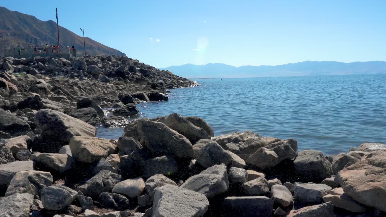 Water gently ripples by rocky shoreline in mountains of Salt Lake Utah
