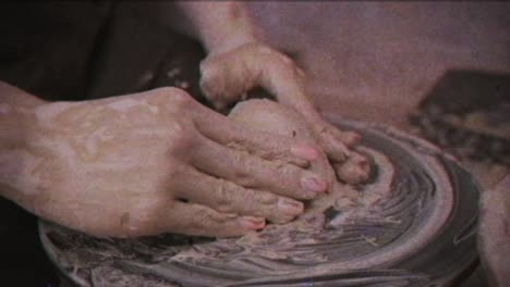 a potter teaches a woman to make clay dishes. a man takes a woman's hands. vintage effect.