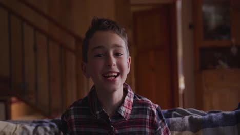 Portrait-of-a-happy-boy-sitting-at-home