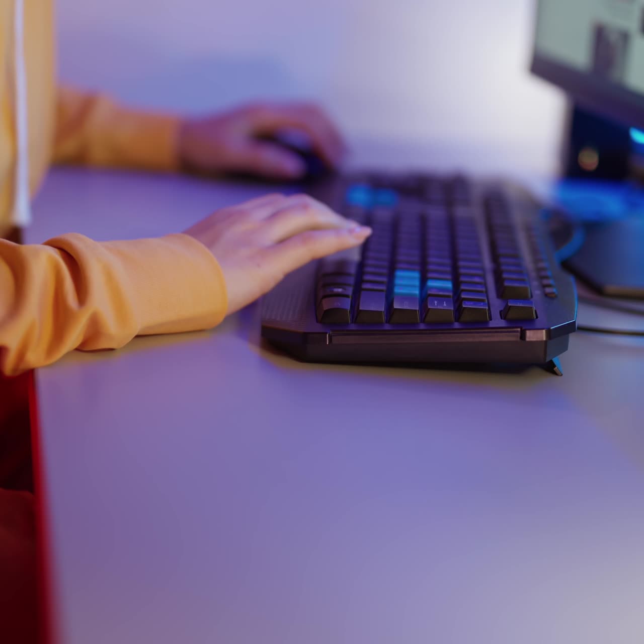 Woman's hands press the buttons on the keyboard. Girl is sitting at the table and and working on the computer. Close-up.