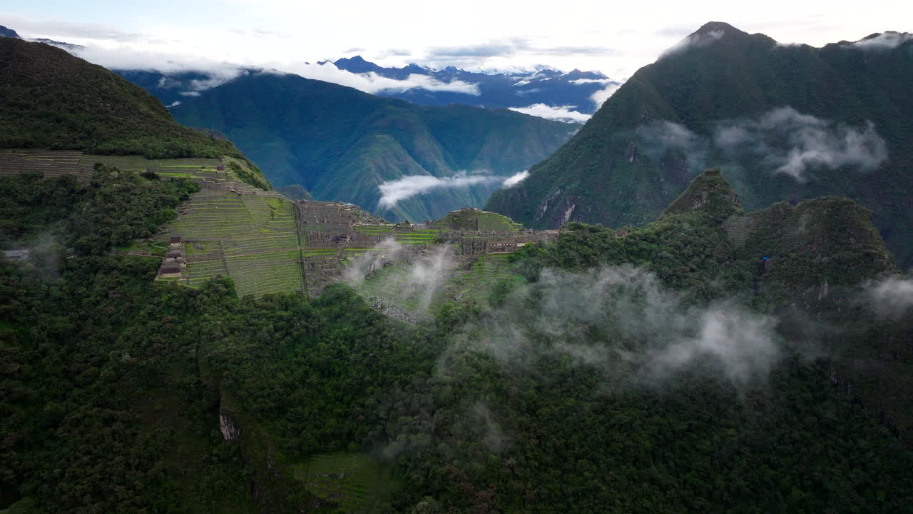 Machu Picchu ruins UNESCO world heritage site atop ridge in Andes, Peru. Aerial