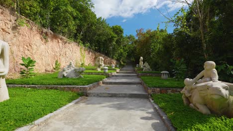 Subiendo-La-Escalera-De-Piedra-En-El-Bosque-Estatuas-Talladas-En-Piedra-A-Cámara-Lenta-Cardán-Push-in-4k