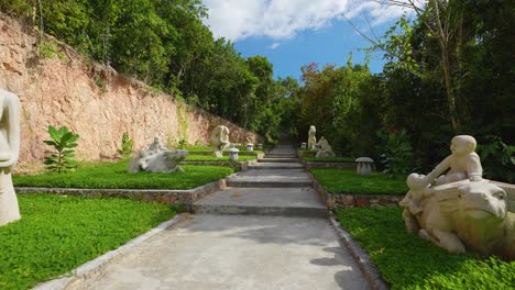 subiendo la escalera de piedra en el bosque estatuas talladas en piedra a cámara lenta cardán push-in 4k