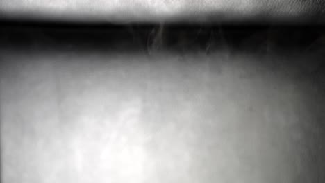 Wispy-tendrils-of-smoke-drop-slowly-from-top-to-bottom-in-slow-motion