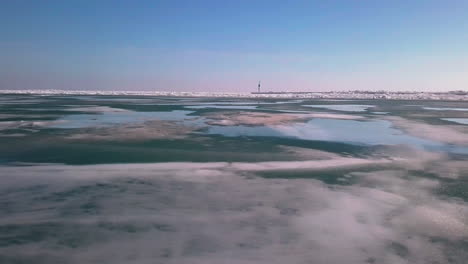 Tiro-Volador-Sobre-Un-Lago-Helado-Para-Revelar-Un-Faro-En-Un-Muelle