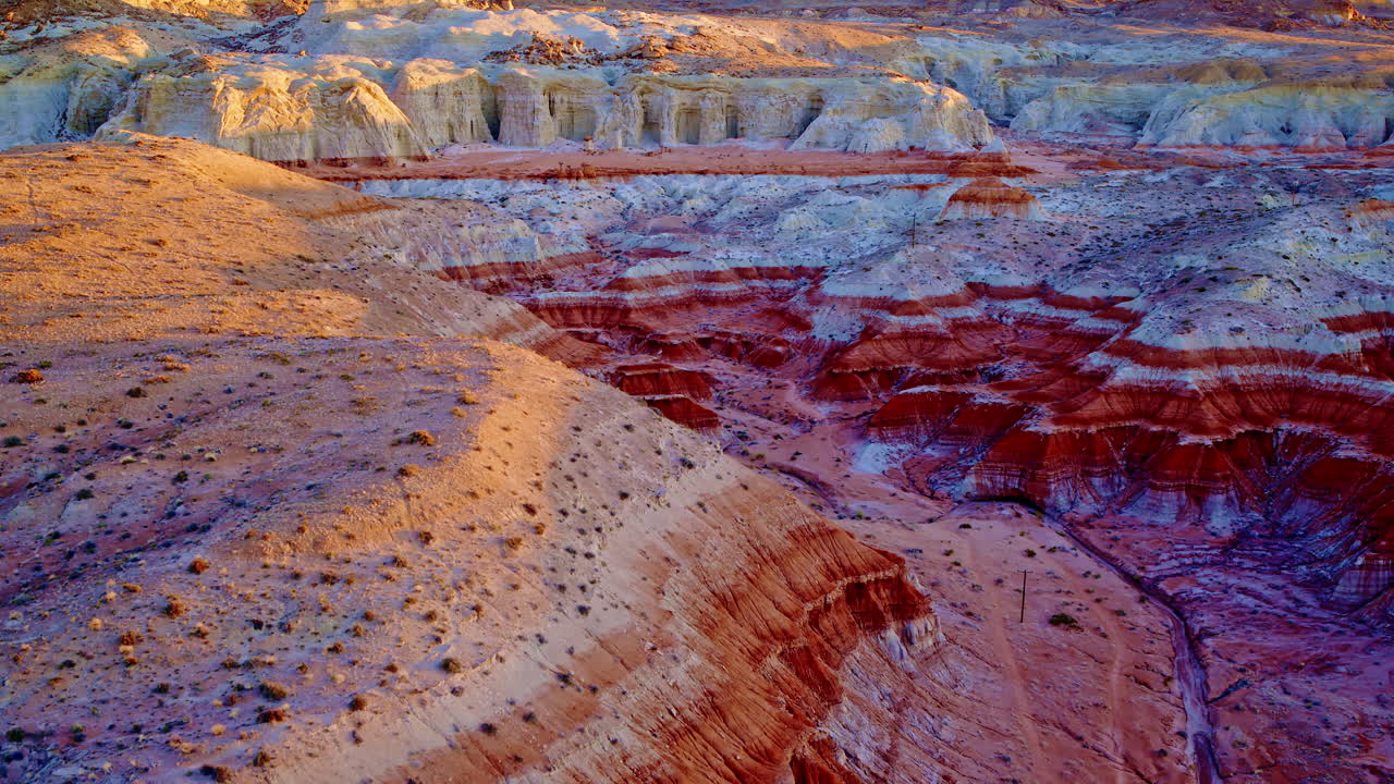 A drone drifts slowly over the dramatic rock formations, hoodoos, and painted hills near the Utah-Arizona border.