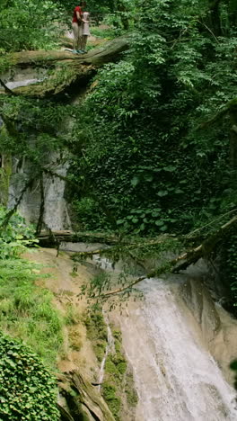 family hiking at waterfall in forest