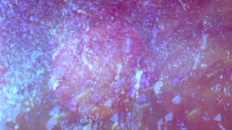 blue nebula made up of small particles moves slowly against a purple background
