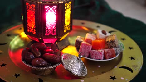 a muslim is drinking water to break the fast. fasting the month of ramadan. iftar table. glass of water, dates, dried fruits, sweets