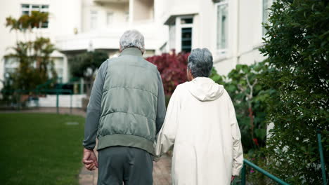 elderly couple walking together in a park