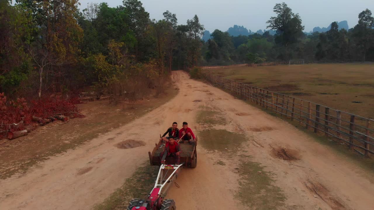Gente del posto con trattore su strada sterrata a Thakhek, Laos