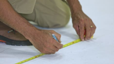 television crew member makes measurements before setting up a stage in broadcast studio