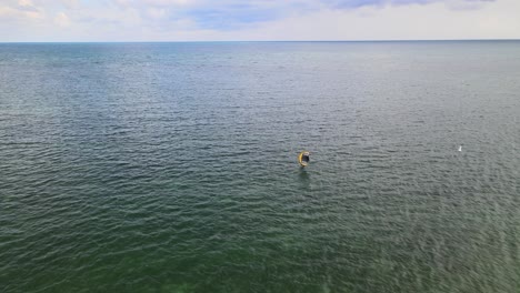 Windsurfer-Auf-Welligem-Meerwasser-Genießt-Einen-Sonnigen-Nachmittag-Vor-Der-Küste-Von-Virginia-Key-In-Miami,-Florida,-Mit-Sonnigem-Himmel-Und-Blauem-Wasser