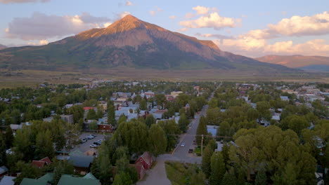 Vista-Aérea-De-Crested-Butte-Trucking-Justo-Sobre-Las-Casas-Y-Calles-De-La-Ciudad-De-Colorado-Con-La-Montaña-En-El-Horizonte