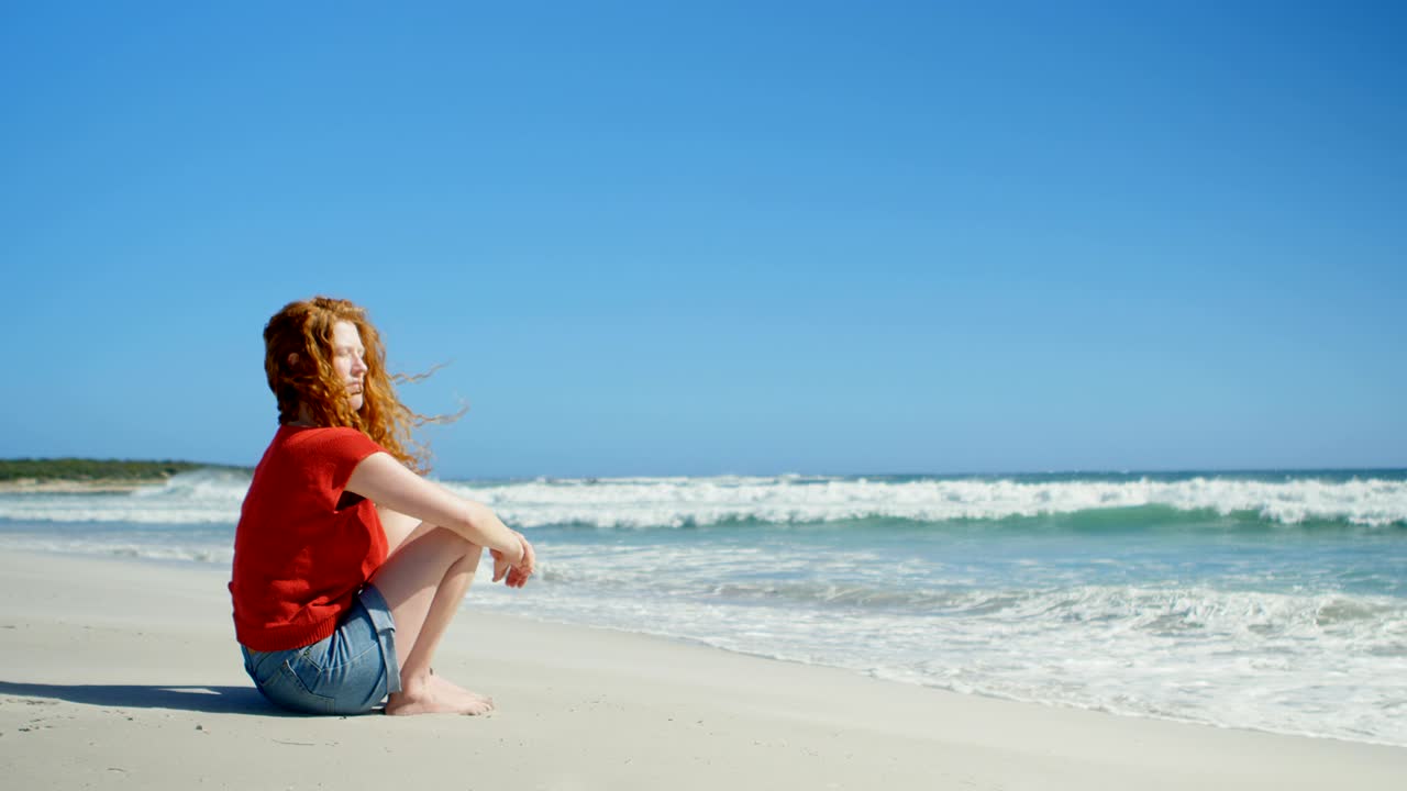 모래 위에 앉아서 바다를 바라보는 여자 4k