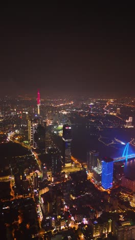 vertical expansive drone shot of saigon’s skyline with the illuminated landmark 81, vibrant bridges, and the glowing saigon river, vietnam