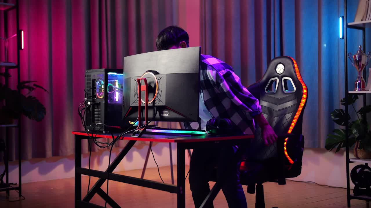 adolescente asiático sentado y comienza a jugar videojuegos en la computadora