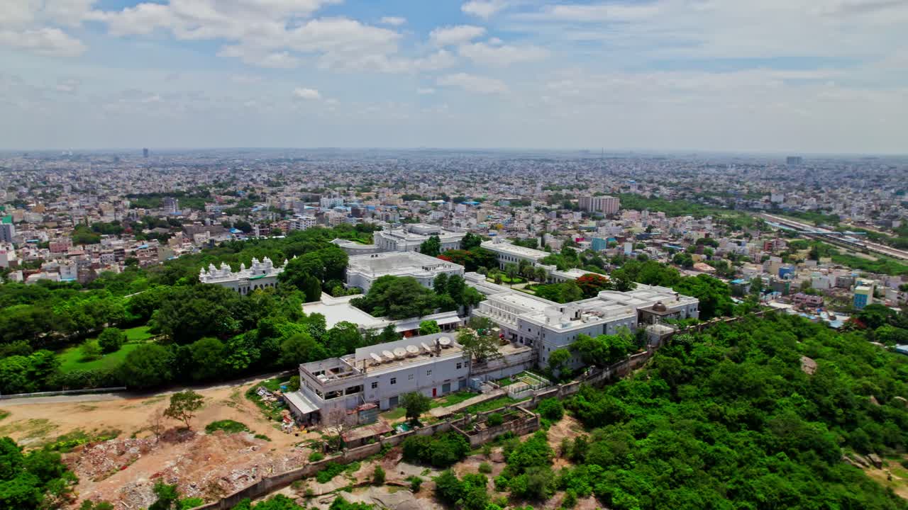 Taj Falaknuma Palace with hyderabad city view, sky and clouds at Engine Bowli, Falaknuma, Hyderabad, Telangana, india. day time, Semi orbit, drone shot, 4k