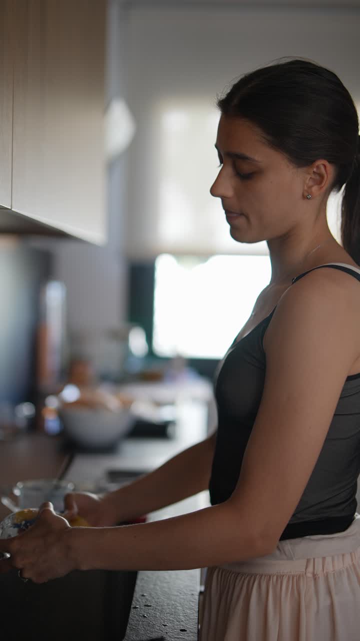 joven lavando platos en la cocina