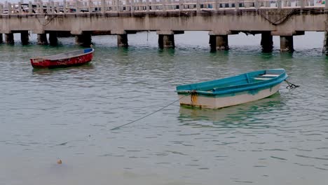 two old row boats moored at a dock in thailand