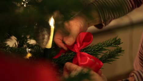 Agregar-Cinta-Roja-En-La-Decoración-Del-árbol-De-Navidad---ángulo-Alto,-Cerrar