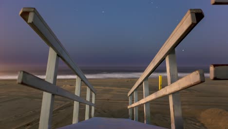 wooden railings of staircase to the manhattan beach at night