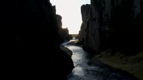 aerial shot through fjaðrárgljúfur canyon towards the sunrise