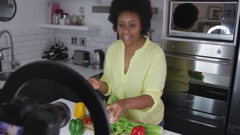 african american female plus size vlogger recording a video about cooking