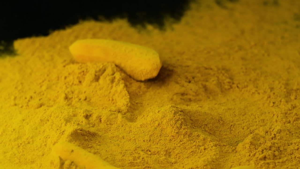 Peeled Turmeric Root Falls On Heap Of Turmeric Powder