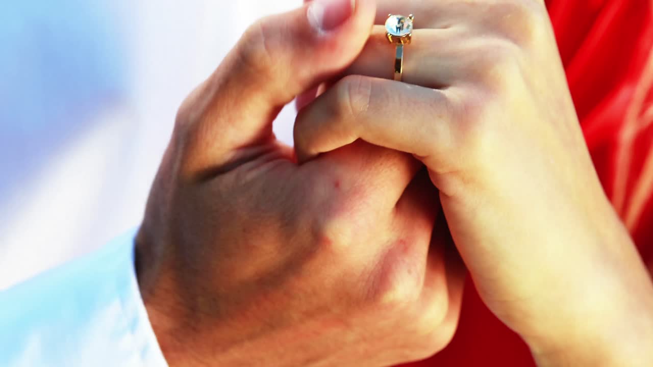 pareja bailando con anillo de compromiso en el parque 4k