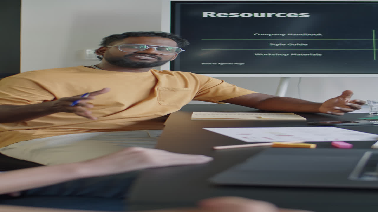 Man Having Discussion with Coworkers at Meeting Table