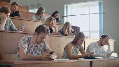 Grupo-Multiétnico-De-Estudiantes-Que-Utilizan-Teléfonos-Inteligentes-Durante-La-Conferencia.-Jóvenes-Que-Usan-Las-Redes-Sociales-Mientras-Estudian-En-La-Universidad.