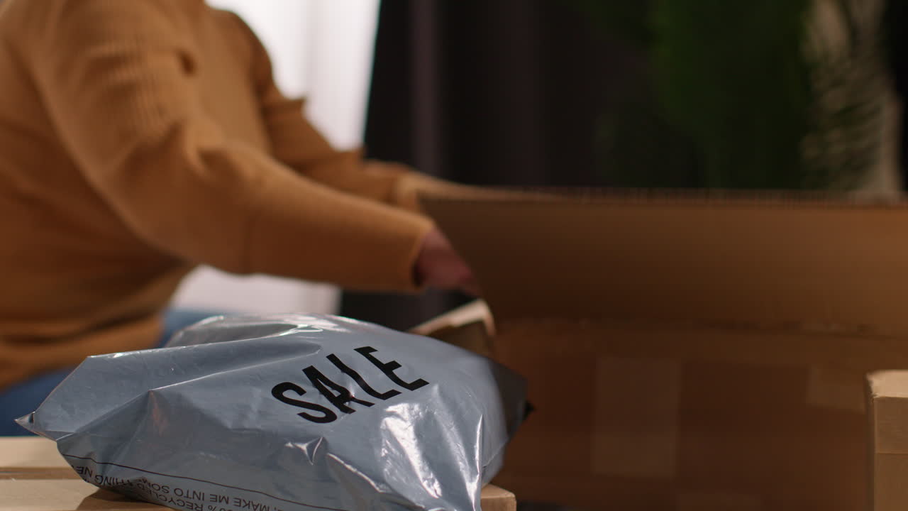 여성이 장식품을 상자에서 꺼내서 판매하고 있습니다.