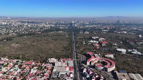 drone footage of insurgentes avenue passing through ciudad universitaria in southern mexico city