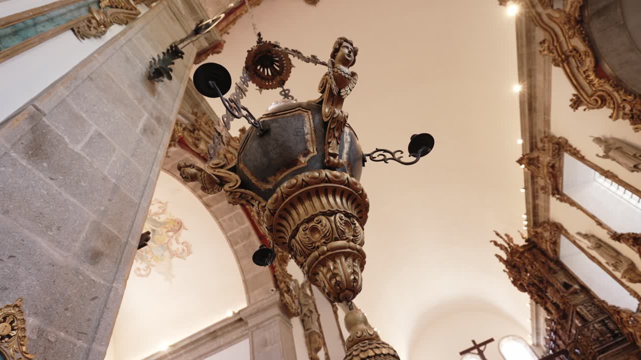 Ornate hanging censer with intricate gold details inside a historic church in Braga, Portugal