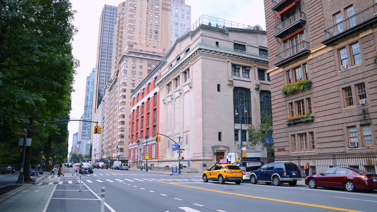 New York, USA, 1 agosto 2025: un taxi giallo si muove lungo la strada e si ferma al semaforo rosso. Mamme con passeggini attraversano la strada. Vita a New York, USA