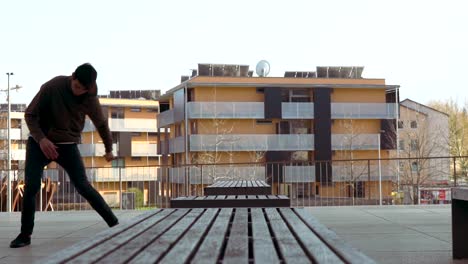 young parkour athlete doing a side flip over a bench in slow motion