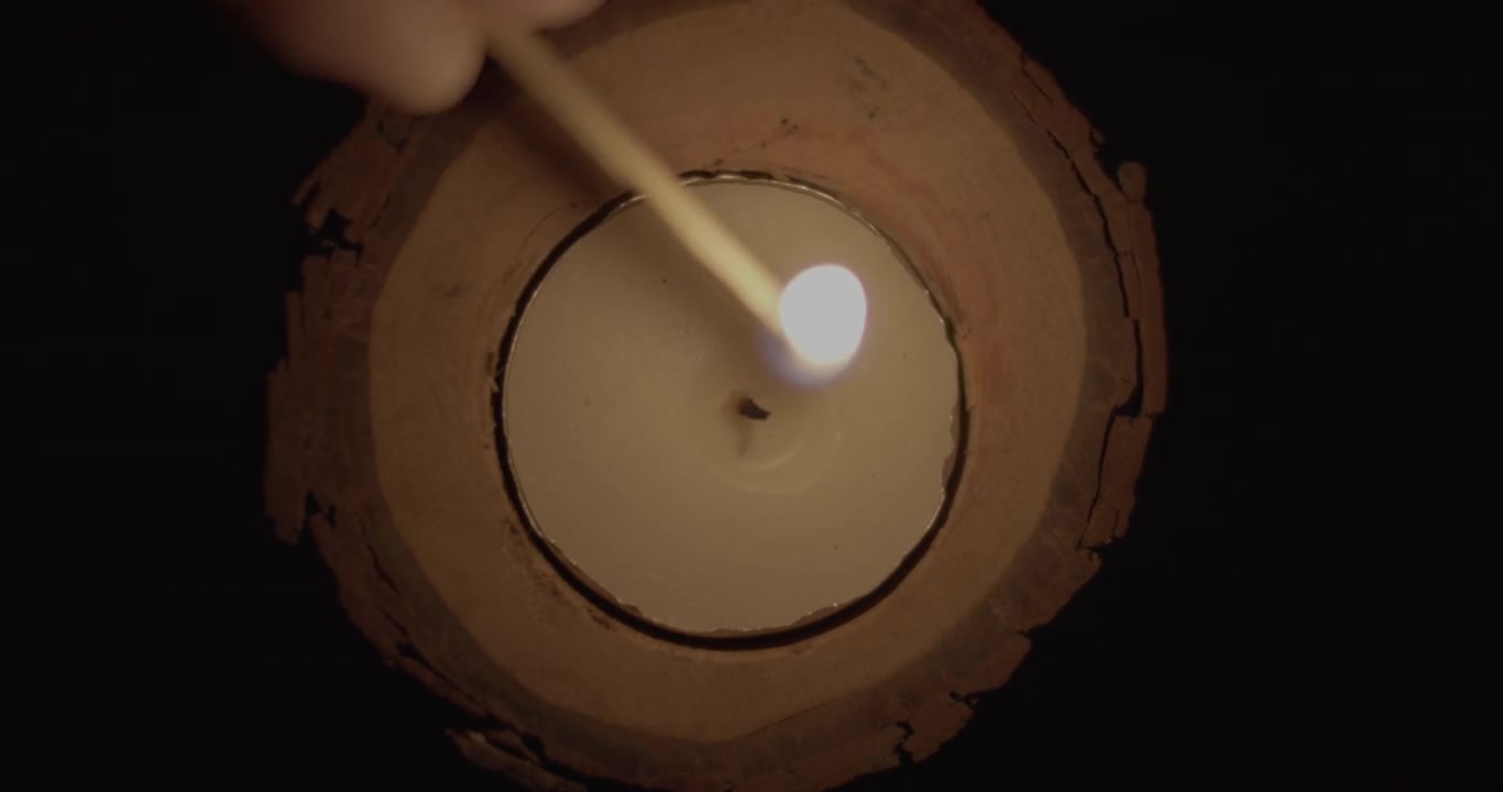 Una persona encendiendo una vela