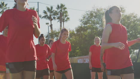 female soccer team warming up during training before match against flaring sun