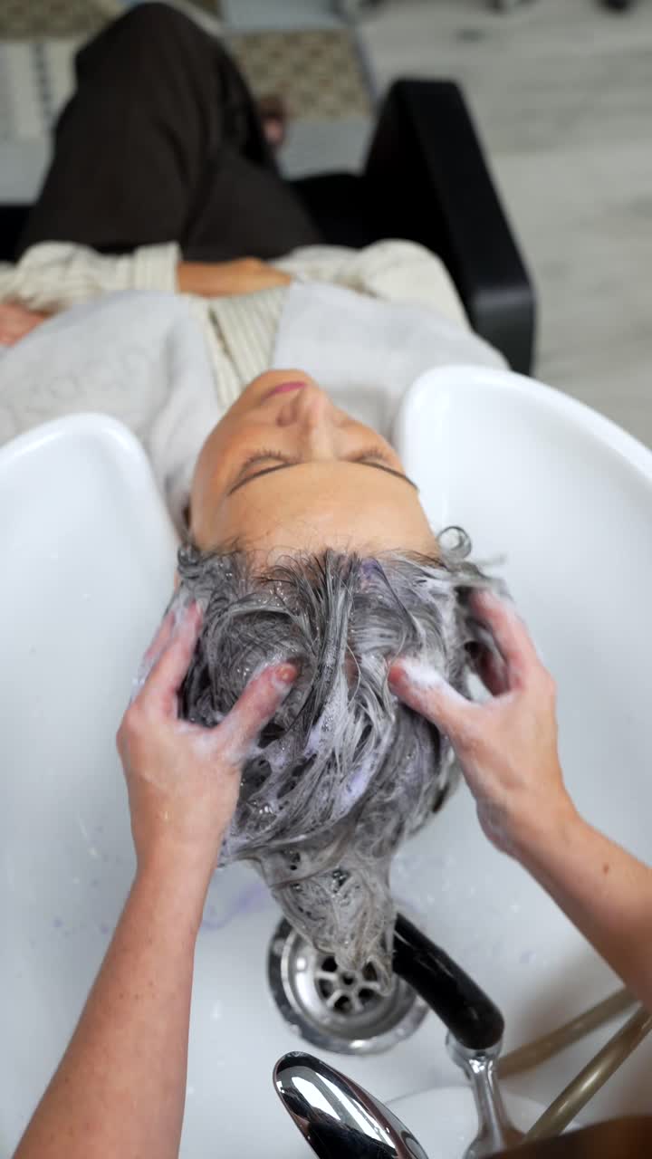 Donna che si lava i capelli al salone