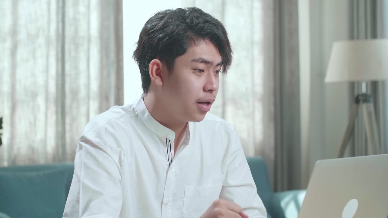 Close Up Of Asian Man Student Celebrating While Using Computer To Study Online At Home