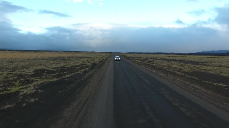 tomada aérea de un avión no tripulado de un coche que conduce fuera de carretera en islandia