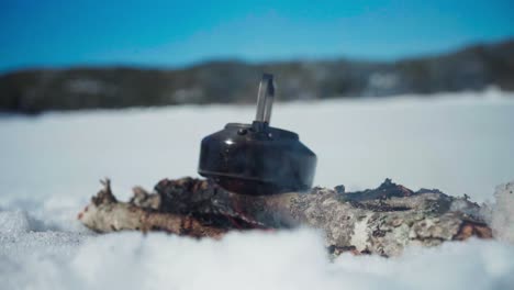 kettle over firewood during winter season