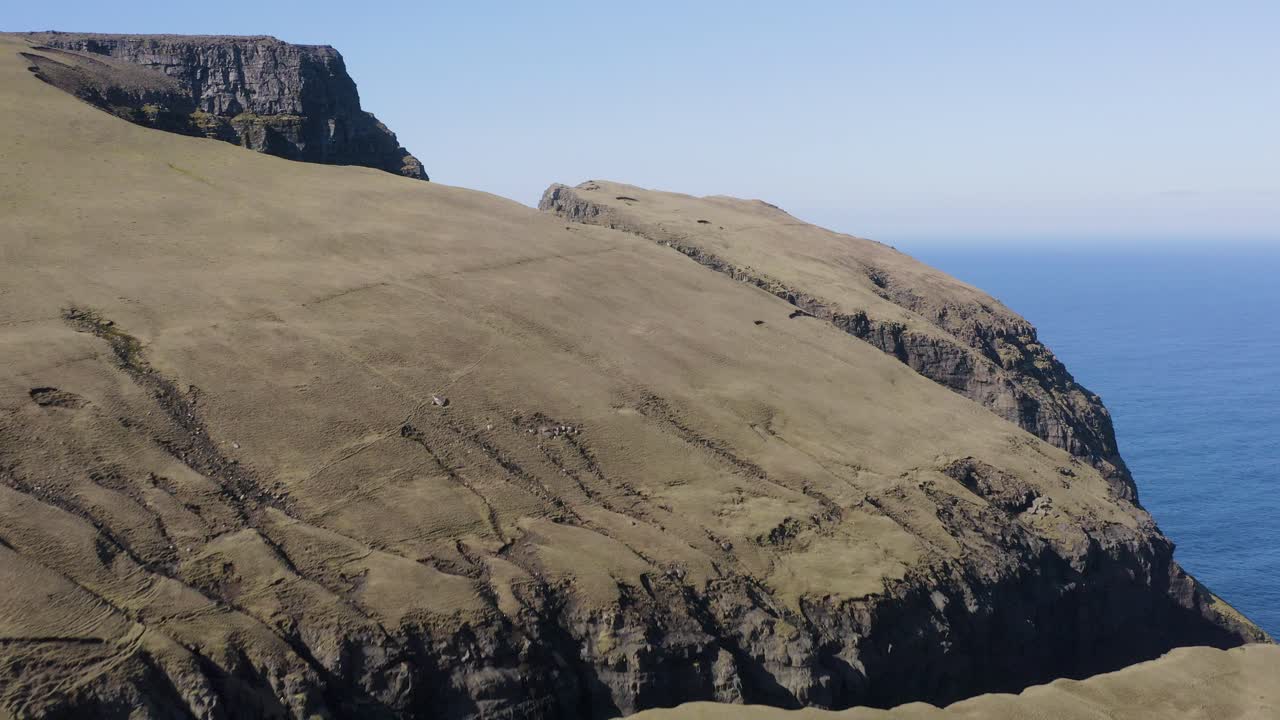 sobrevuelo aéreo de las montañas de las islas feroe con el desfiladero de rituskor en la isla de suduroy en el cielo azul