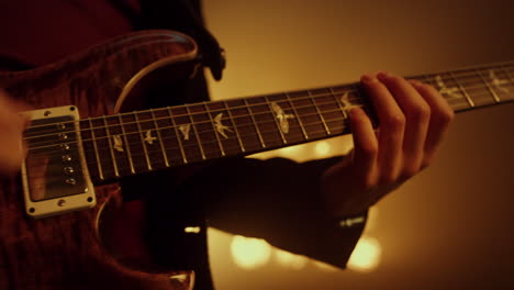 Guitarist-hands-playing-guitar-on-stage-club-close-up.-Player-performing-music.