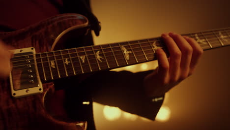 las manos del guitarrista tocando la guitarra en el club de escenario de cerca. jugador tocando música.