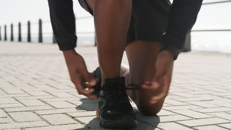 an unrecognisable man tying his shoelace while out